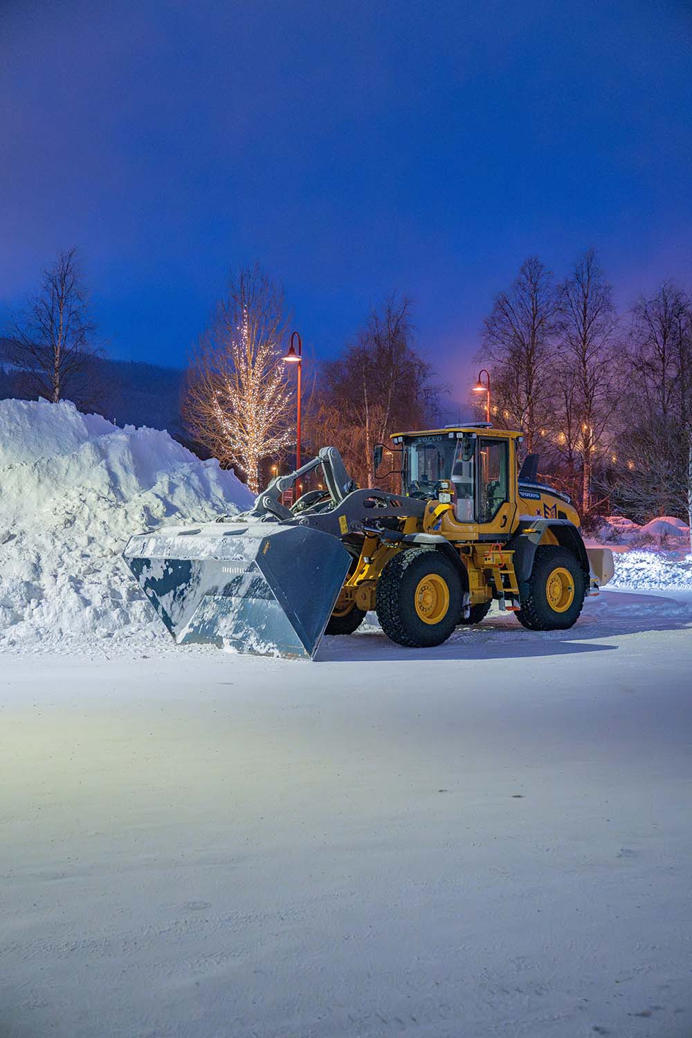 Digger in snow with Christmas lights