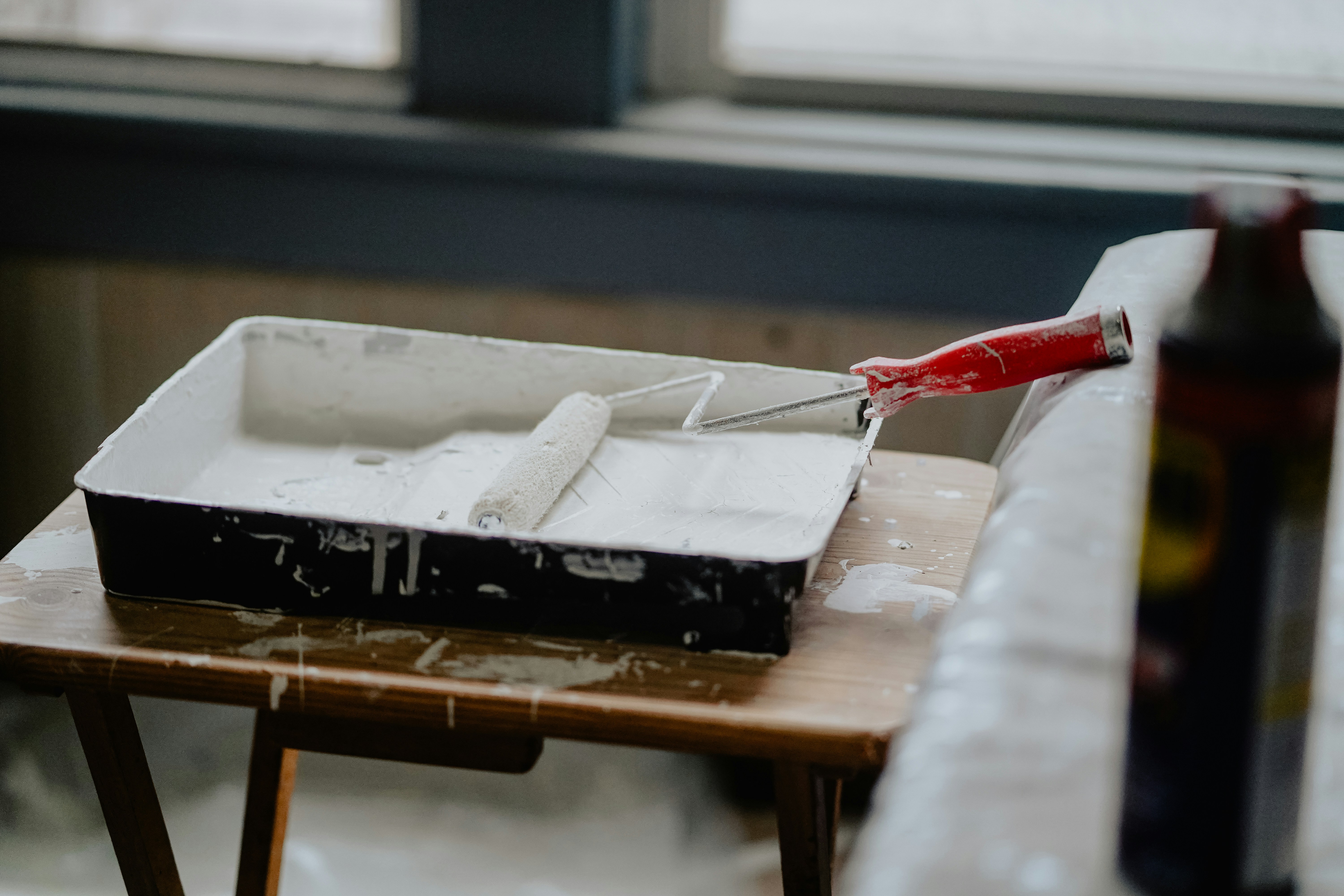 white house paint sitting in pan with paint roller