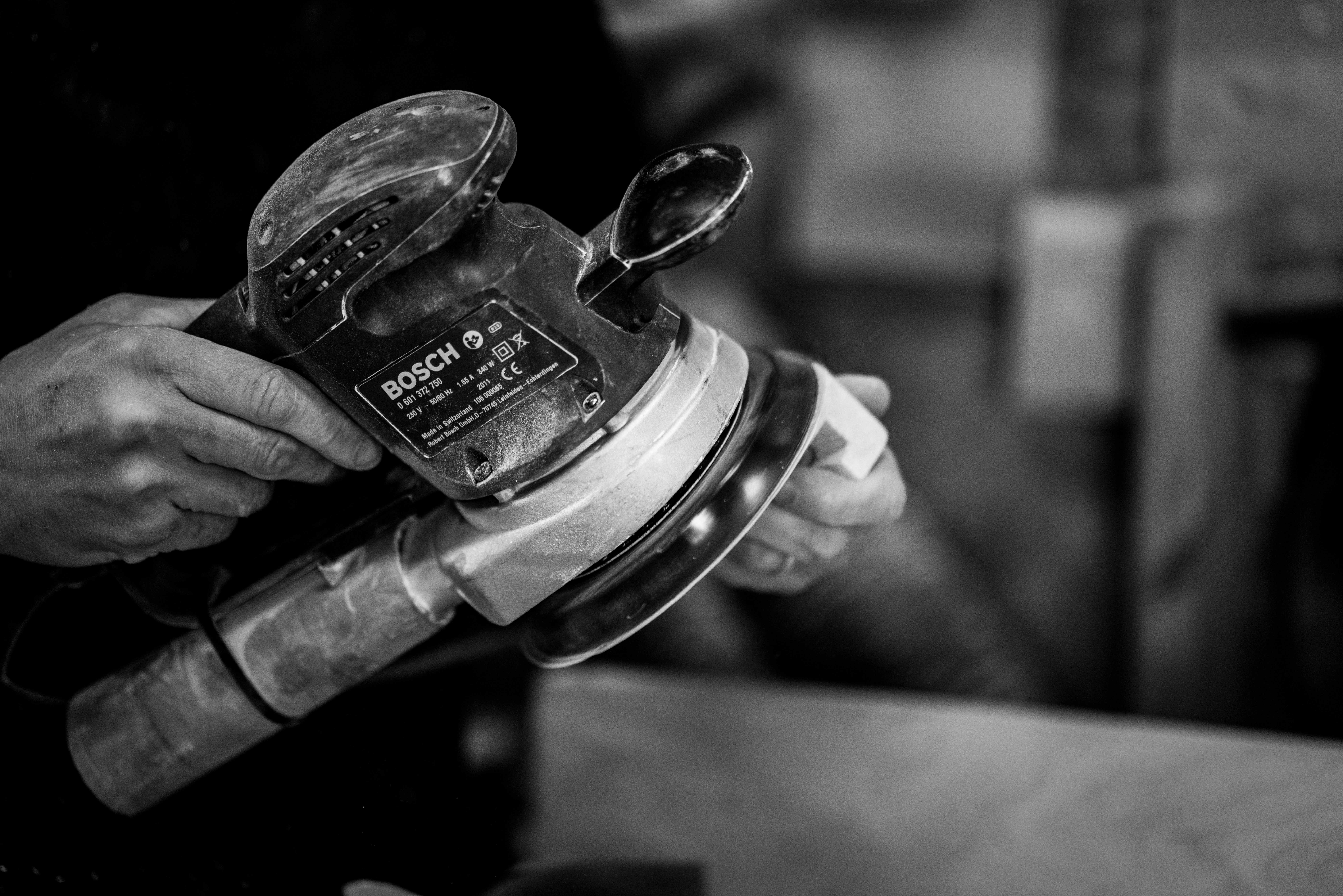 Black and white picture of a man using a sander