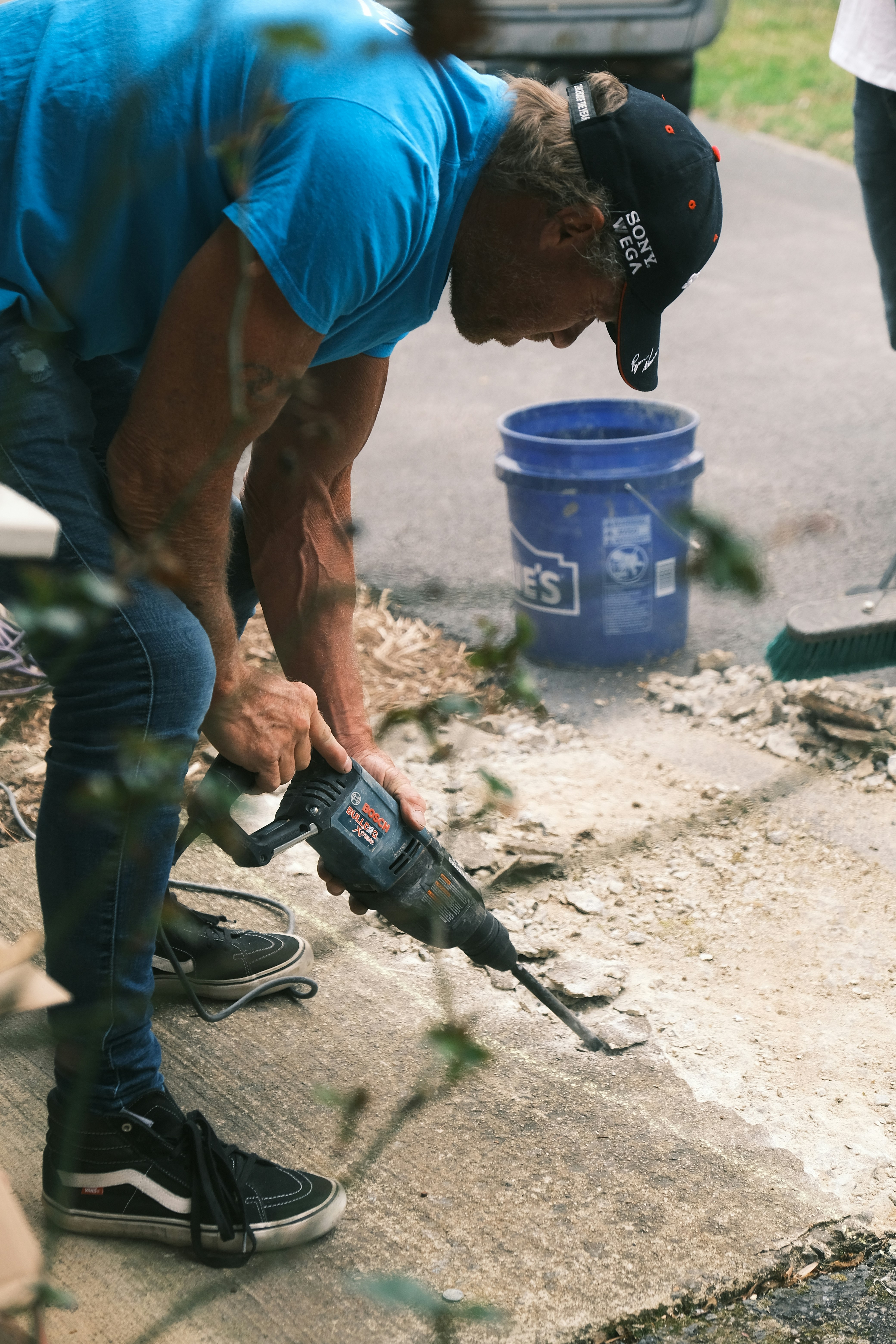 Man using mini digger on concrete floor