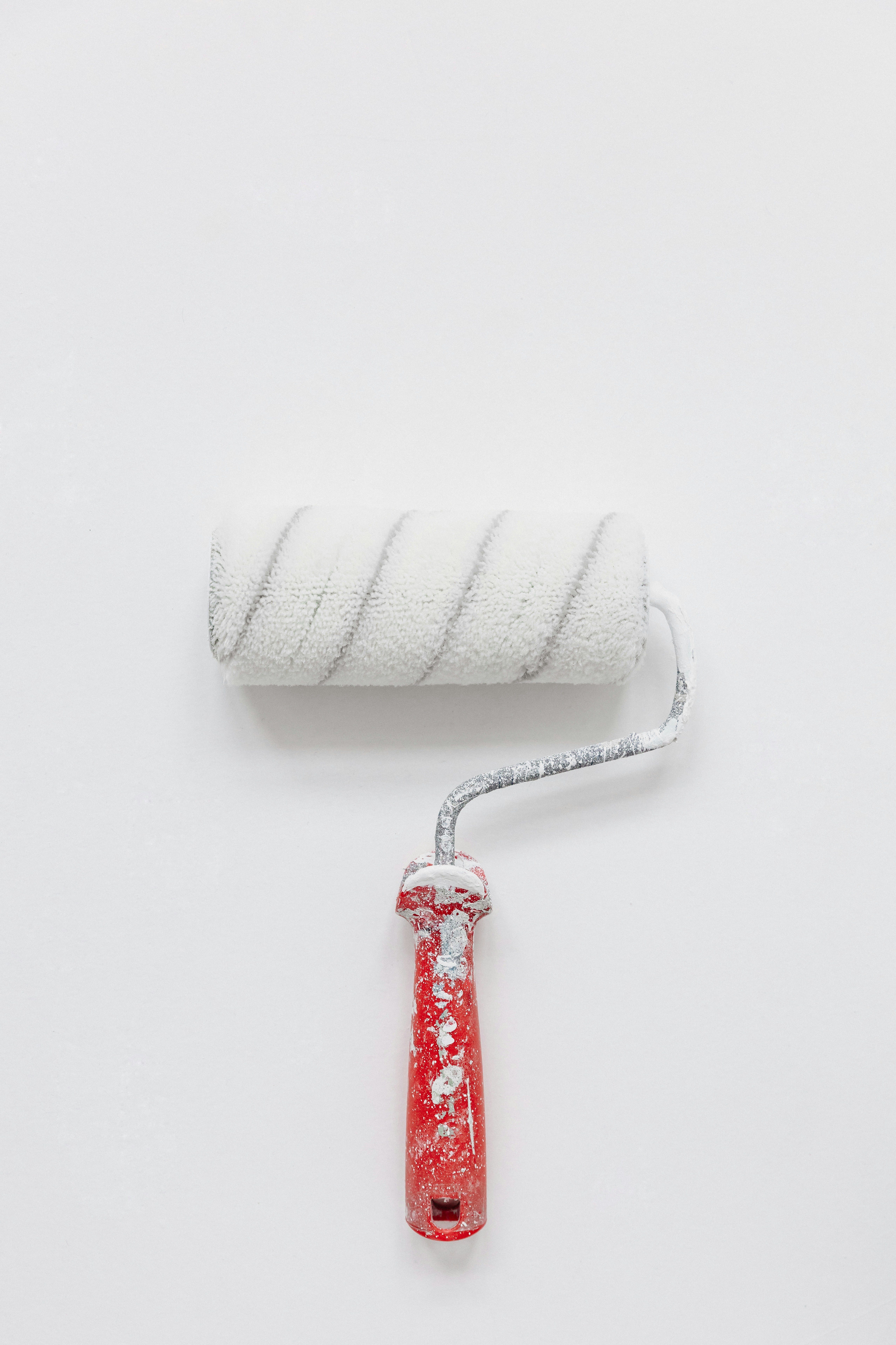 Painting roller with a white paint splashes on handle and white background